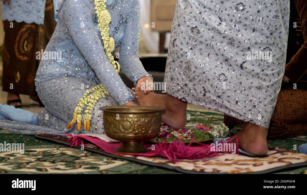 La mariée lave les pieds de marié lors d'une cérémonie de mariage traditionnelle Banque D'Images