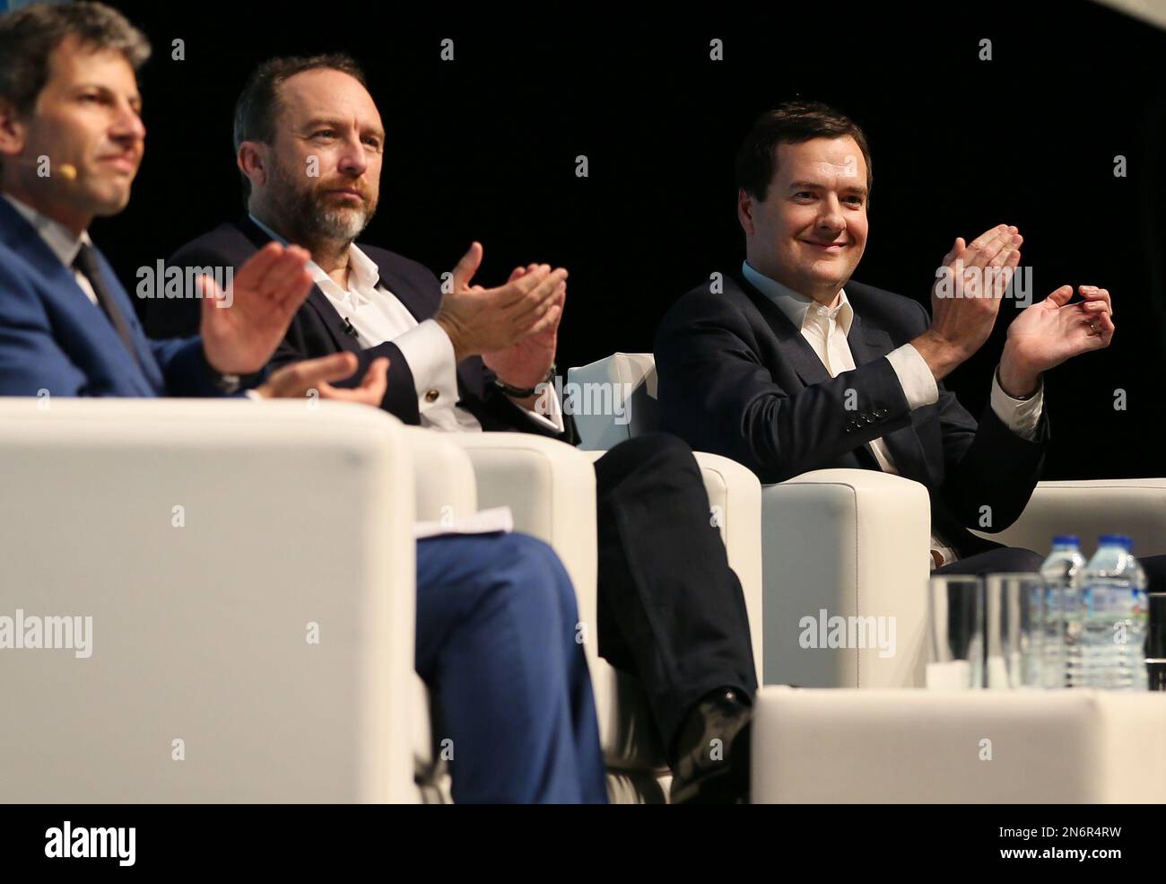 Britain's Chancellor of the Exchequer George Osborne, right, Jimmy Wales founder of Wikipedia, center, and David Rowan, editor of Wired magazine, applaud as British teenage coder and app maker Nick D'Aloisio, unseen, takes the stage at the Campus Party computer coding event at the 02 in London, Wednesday, Sept. 4, 2013. (AP Photo/Alastair Grant, Pool) Banque D'Images