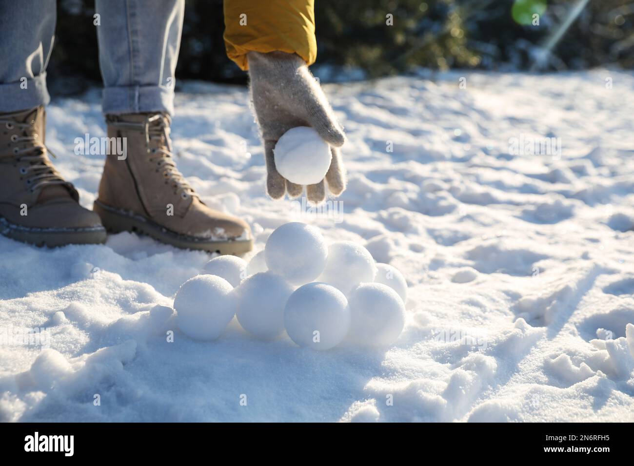 Femme roulant des boules de neige à l'extérieur le jour d'hiver, gros plan Banque D'Images