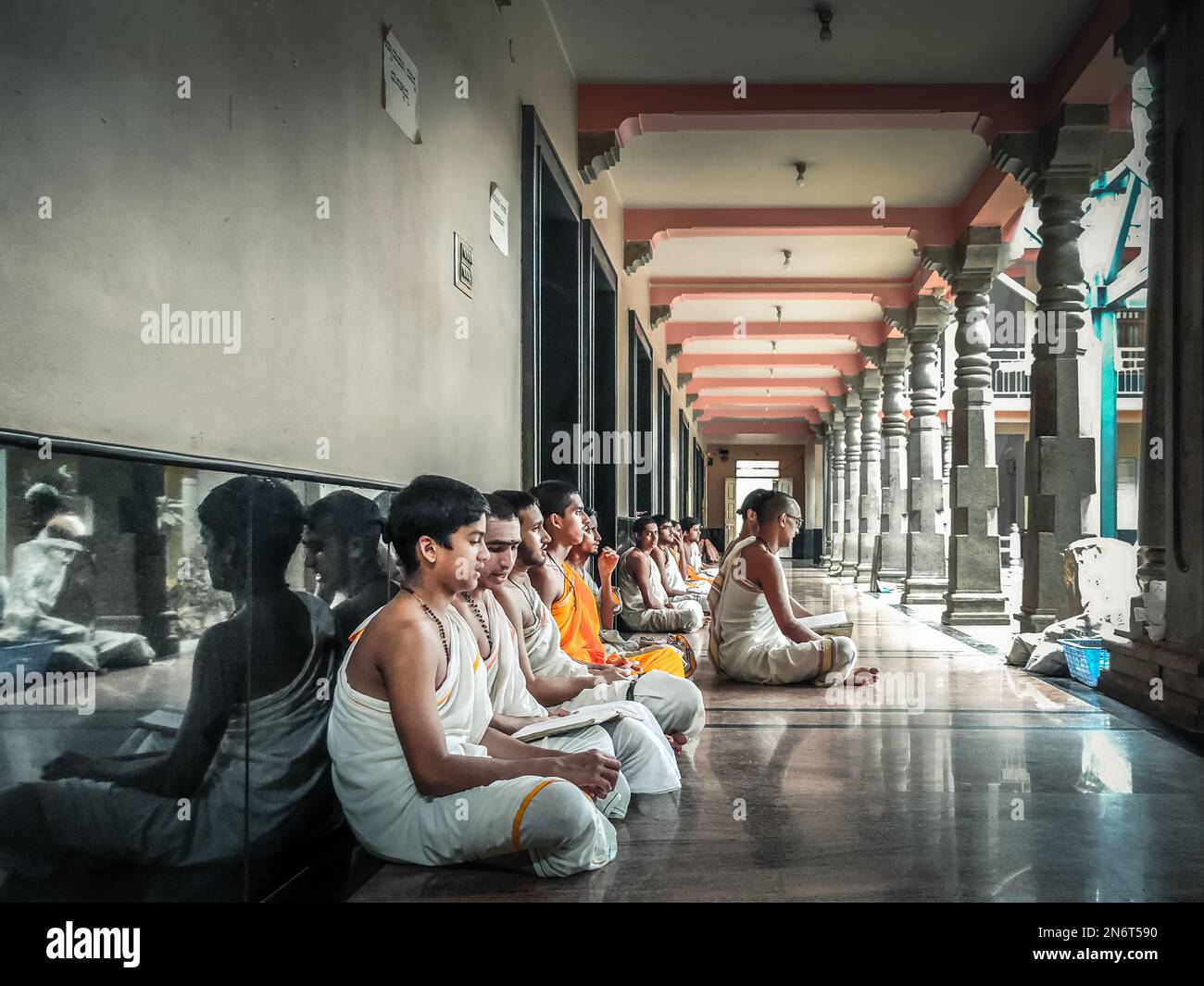 Un groupe de jeunes garçons assis sur le terrain et lisant des livres à l'école d'étude religieuse hindoue védique Banque D'Images