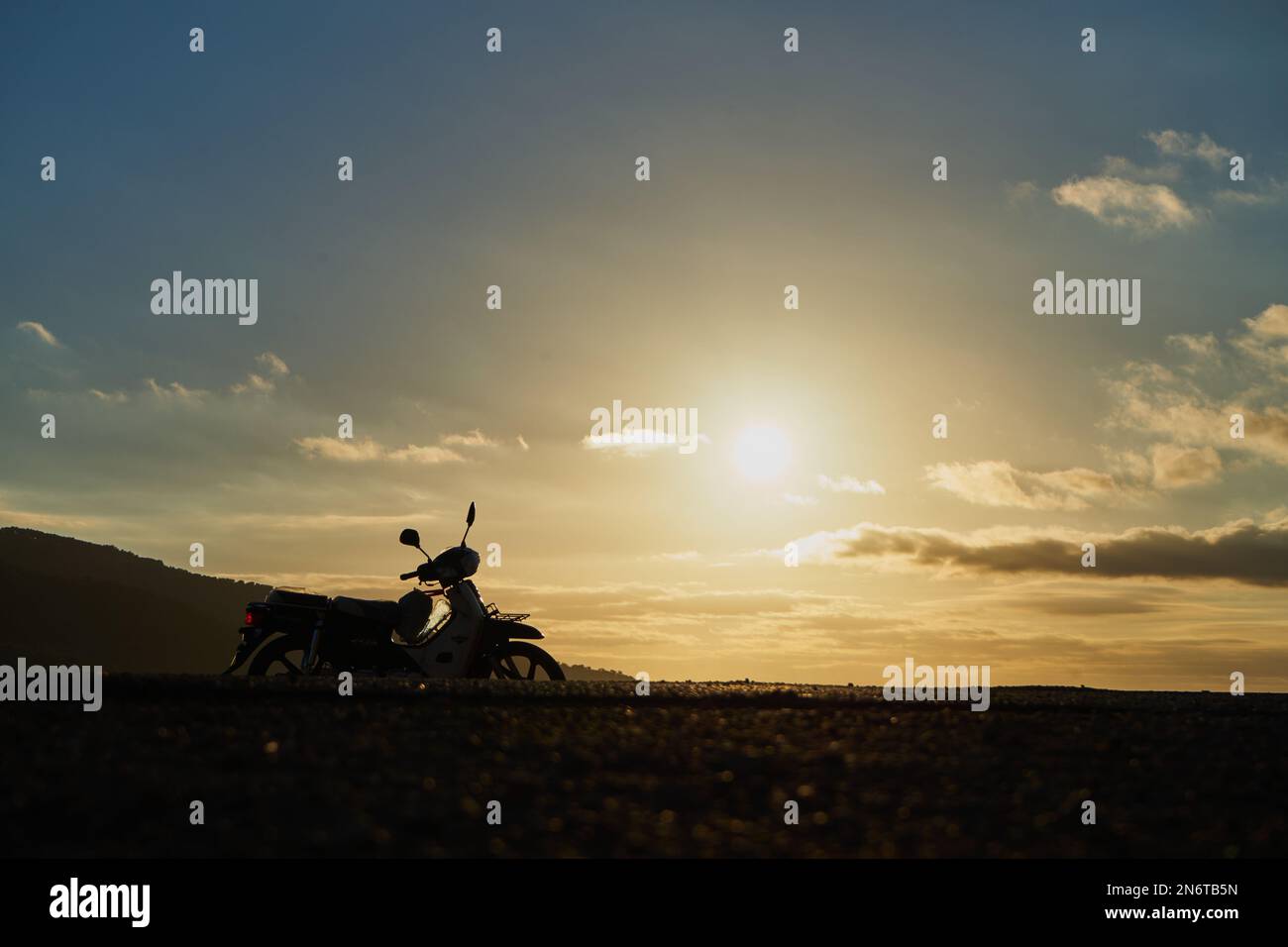 Une silhouette de moto sur une route de montagne Banque D'Images