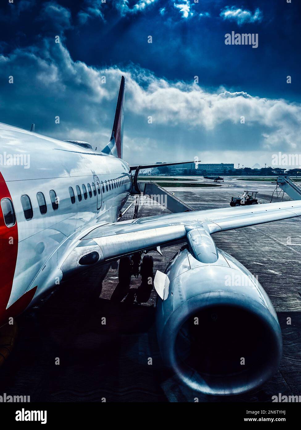Avion commercial générique sur tarmac avec ciel moody. Banque D'Images