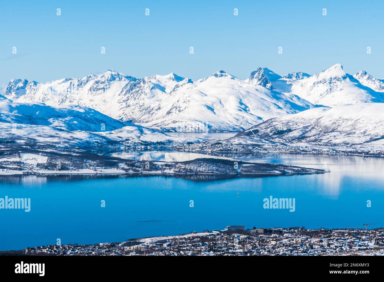 Vue sur la ville norvégienne de Tromso en Norvège et sur les montagnes enneigées et les fjords au-delà, espace copie Banque D'Images