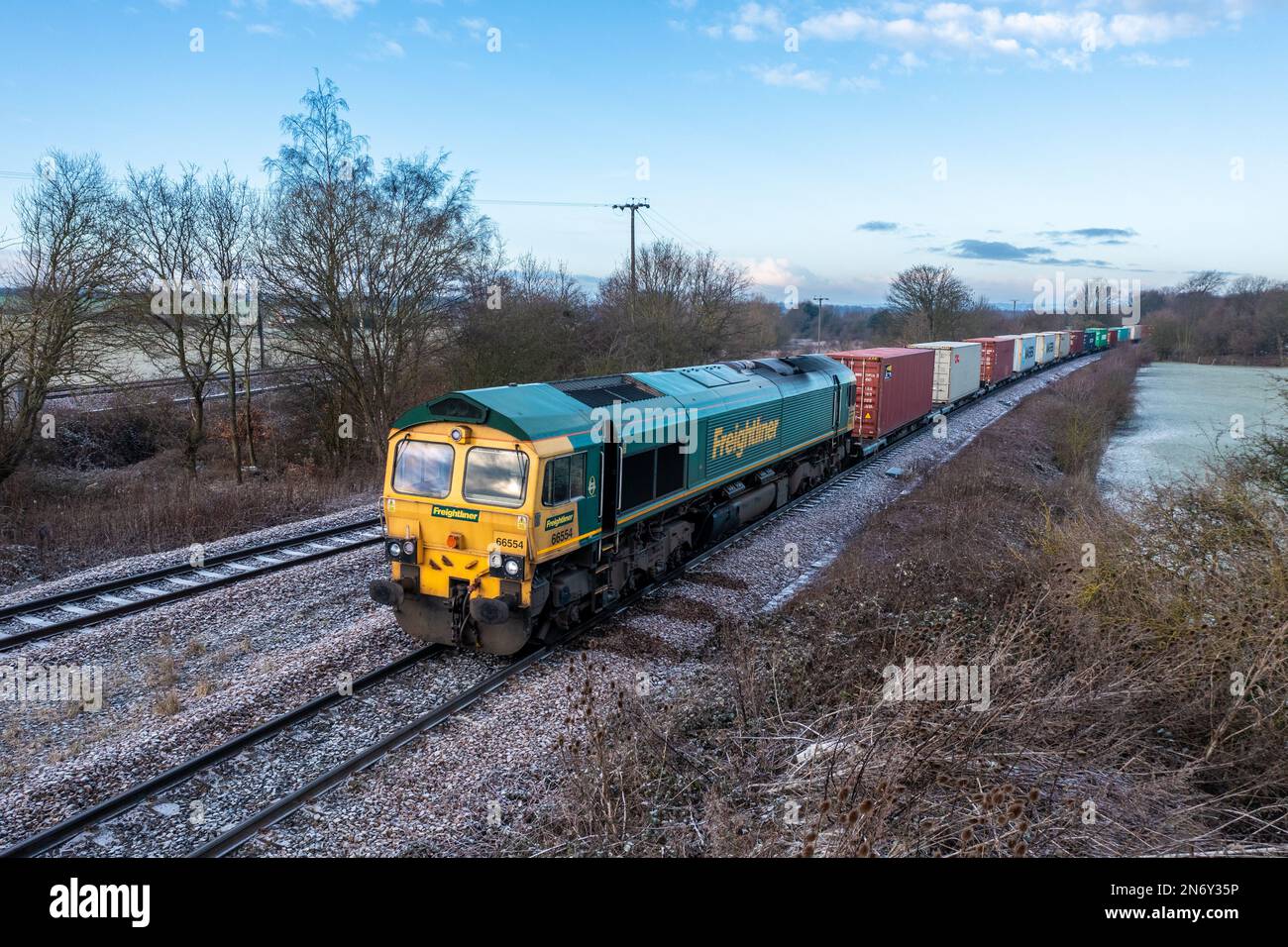 WAKEFIELD, ROYAUME-UNI - 19 JANVIER 2023. Une locomotive intermodale Freightliner tirant un train de conteneurs d'expédition entre le port et le terminal au Royaume-Uni Banque D'Images