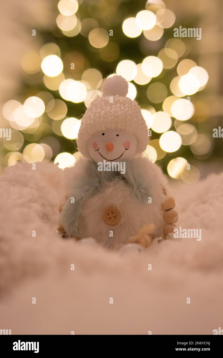 Figurine bonhomme de neige avec lumières bokeh en arrière-plan Banque D'Images