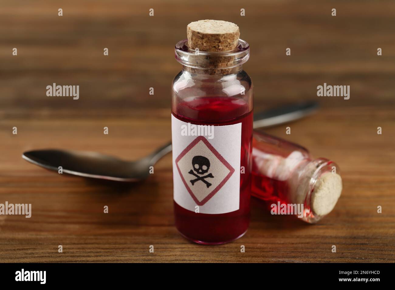 Flacons de poison avec cuillère sur table en bois, gros plan Banque D'Images