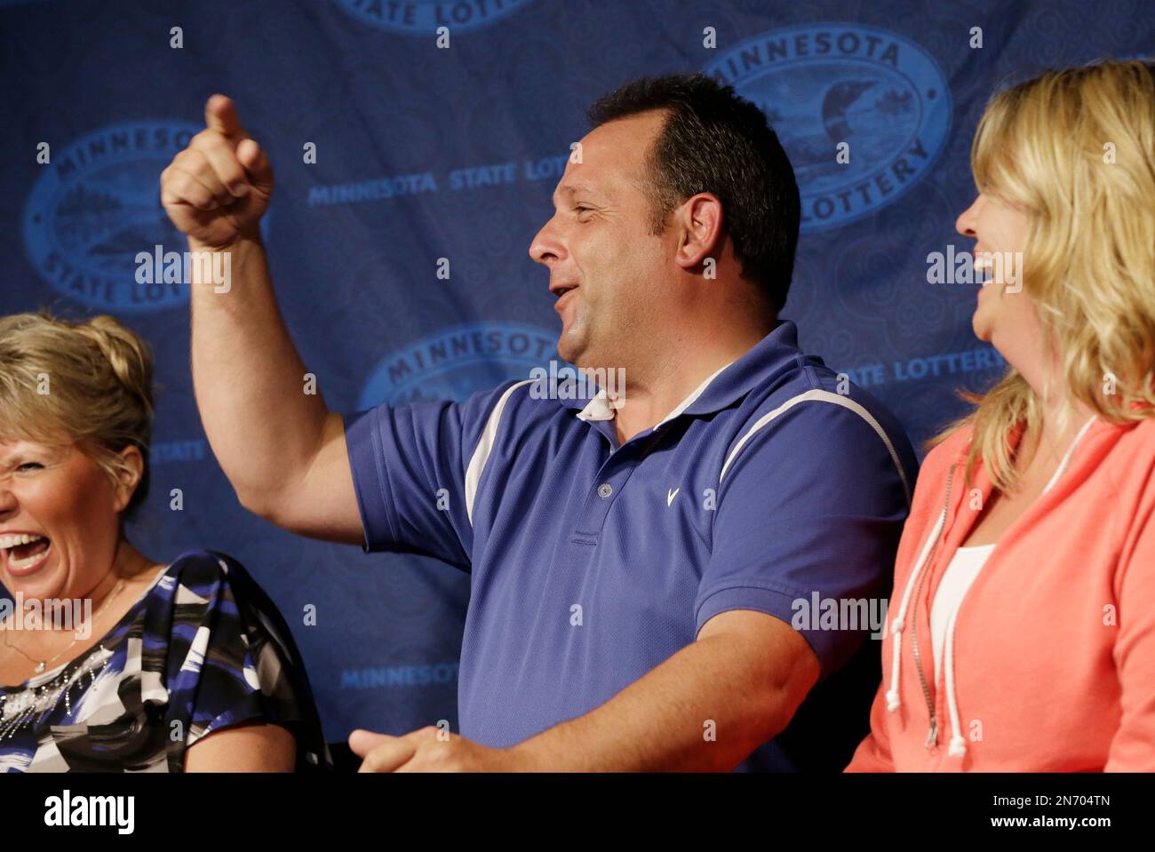 Paul White, of Ham Lake, Minn. accompanied by his girlfriend Kim VanRees, right, lets out a holler during a news conference after he was announced as one of the winners of the $448.4 million Powerball Jackpot, Thursday, Aug. 8, 2013 in Minneapolis. White's share of the jackpot is $149.4 million. The woman at left is a co-worker friend. (AP Photo/Jim Mone) Banque D'Images