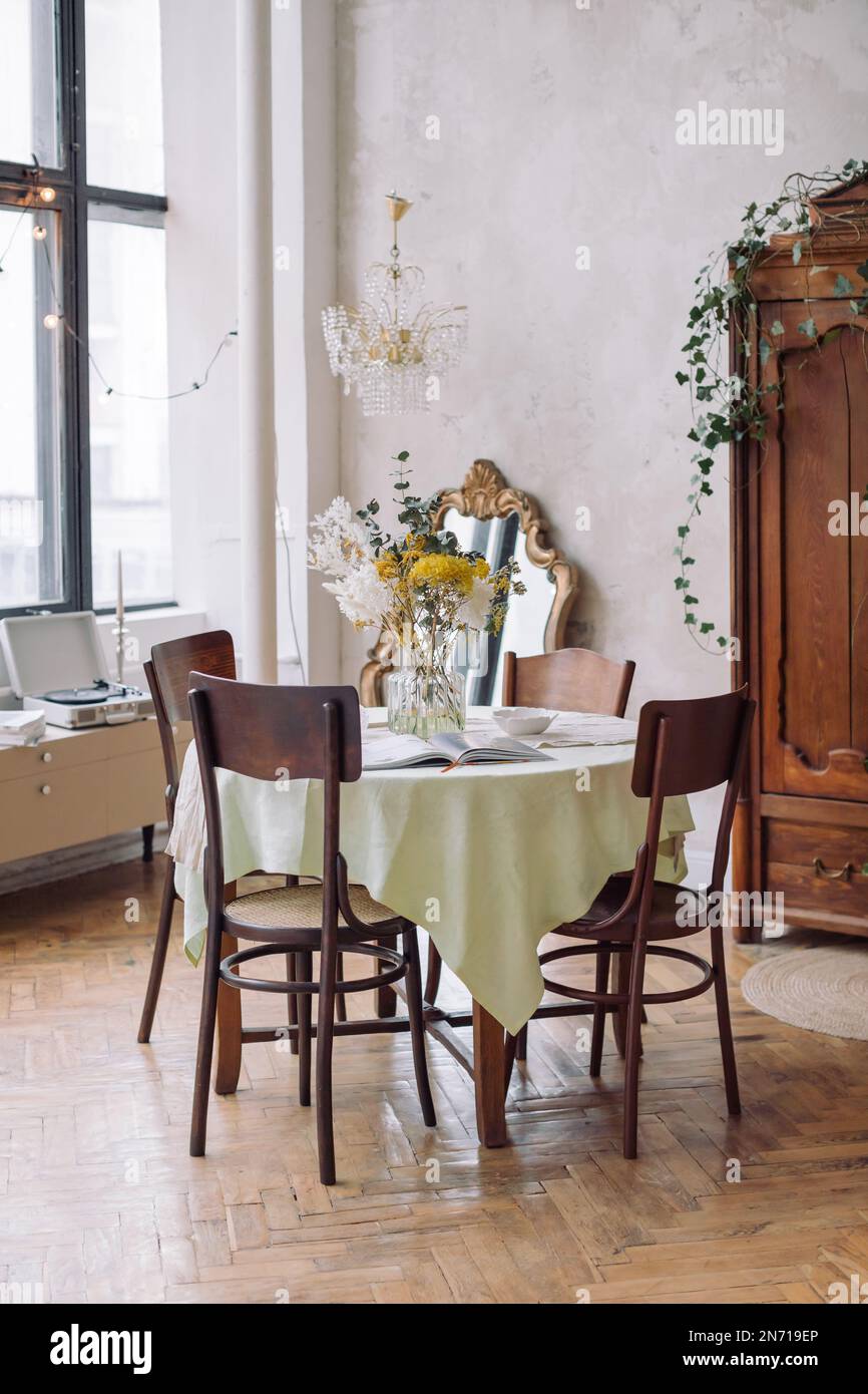 Vase de fleurs rustiques sur une table à manger dans une salle à manger Banque D'Images