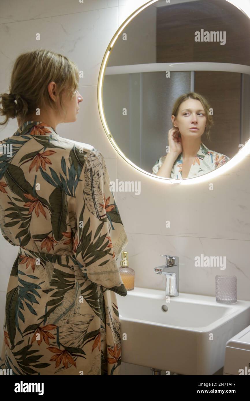 Jeune femme faisant sa routine du matin ou du soir à l'avant du miroir dans la salle de bains, l'hygiène personnelle et le concept de beauté Banque D'Images