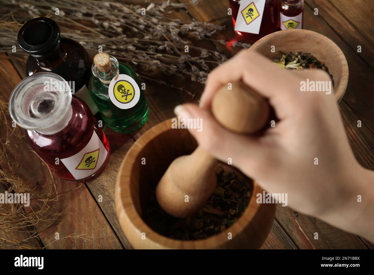 Femme préparant le poison à une table en bois, gros plan Banque D'Images