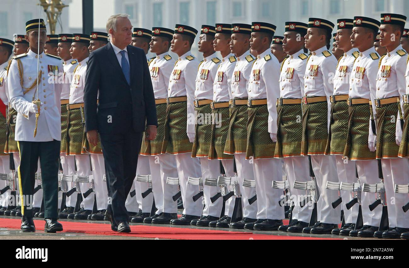 France's Prime Minister Jean-Marc Ayrault, second from left, inspects a guard of honor during a welcome ceremony in Putrajaya, Malaysia, Monday, July 29, 2013. Ayrault is on a two-day official visit to Malaysia. (AP Photo/Lai Seng Sin) Banque D'Images