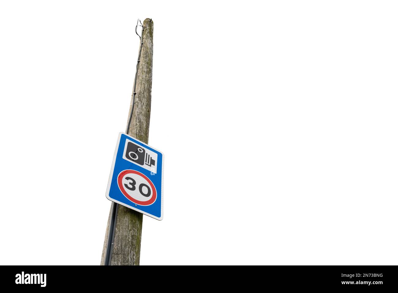 30 km/h et signal d'avertissement de la caméra de vitesse vus fixés à un poteau de télégraphe dans un endroit rural qui a des problèmes avec les voitures de vitesse. Banque D'Images