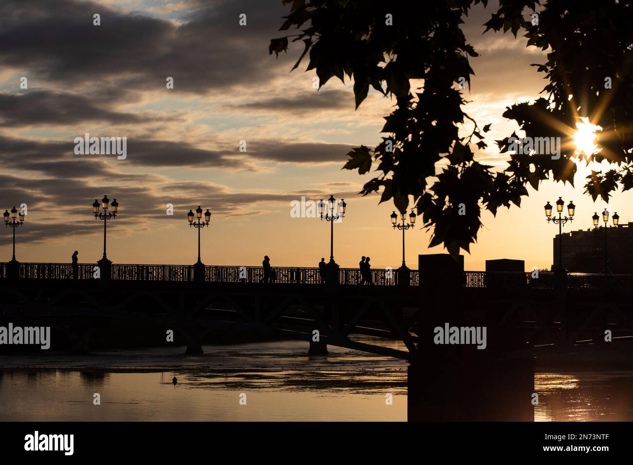 Les gens qui traversent le pont au coucher du soleil. Toulouse , France Banque D'Images
