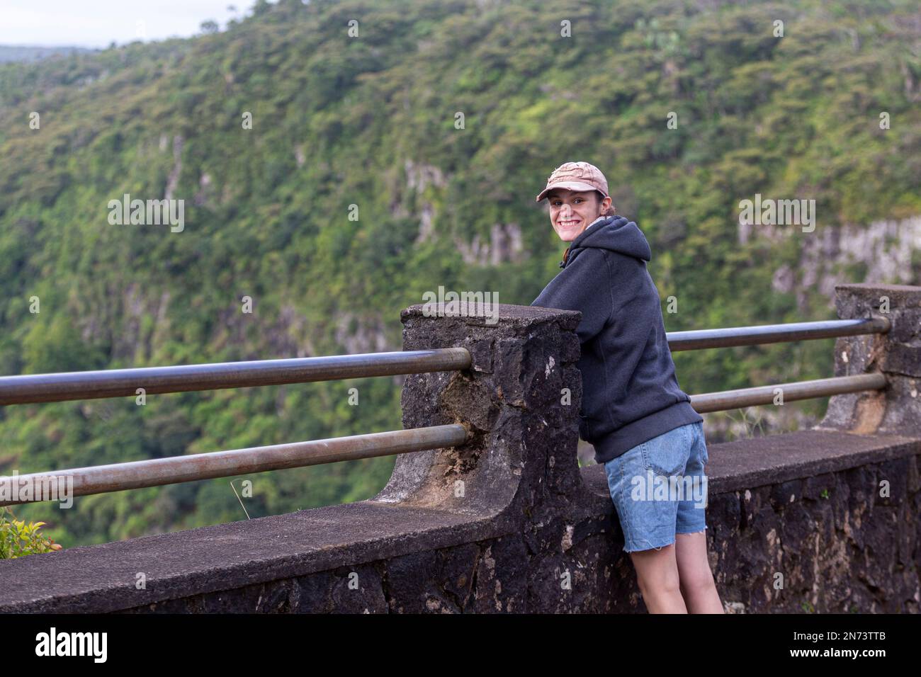 Une jeune femme qui bénéficie d'une vue panoramique sur le parc national des Gorges de la rivière Noire, le point de vue des Gorges à Maurice. Elle couvre une superficie de 67,54 km, y compris une forêt humide de hautes terres, une forêt plus sèche de basses terres et une lande marécageuse. Banque D'Images