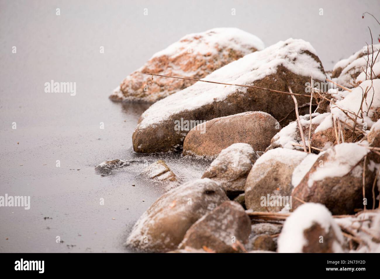Pierres enneigées, rive du lac, hiver Banque D'Images