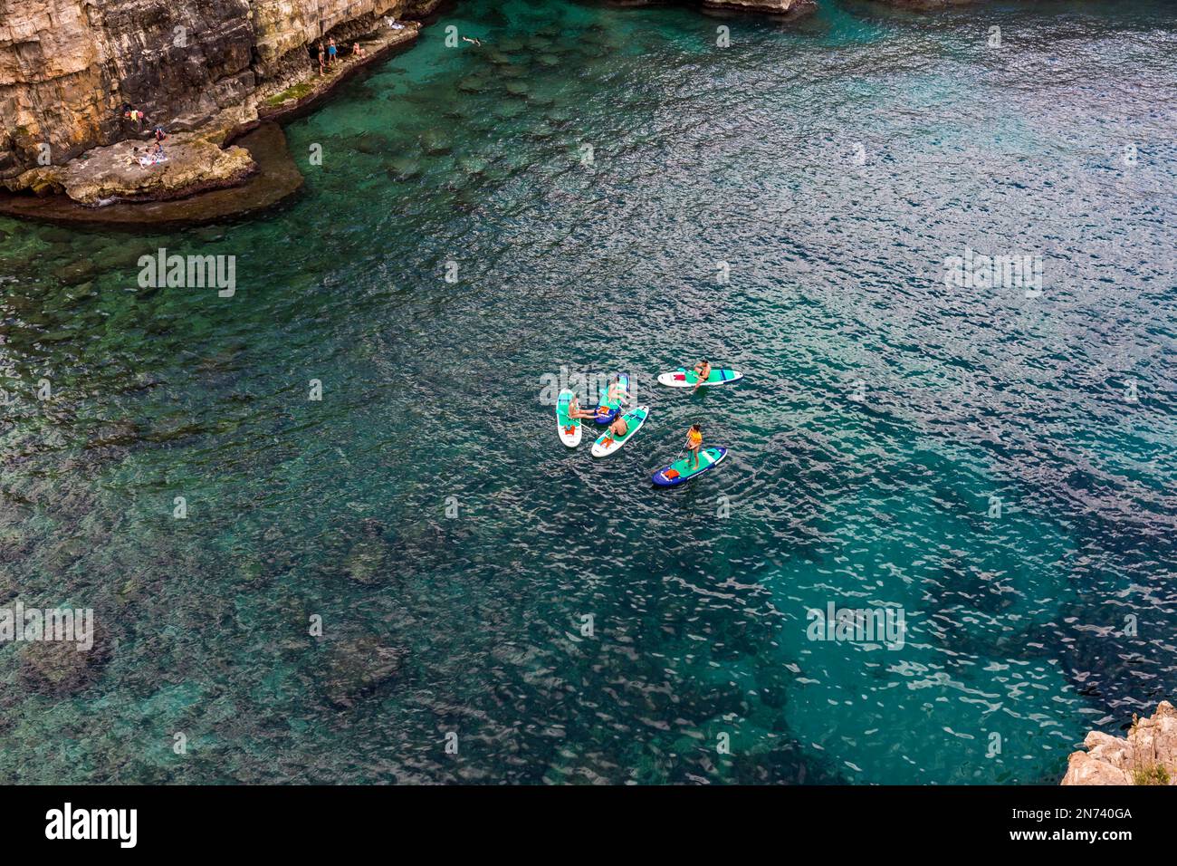 Sup pagayeurs dans l'eau, Lama Monachile, Polignano a Mare, Puglia, Italie du Sud, Italie, Europe Banque D'Images