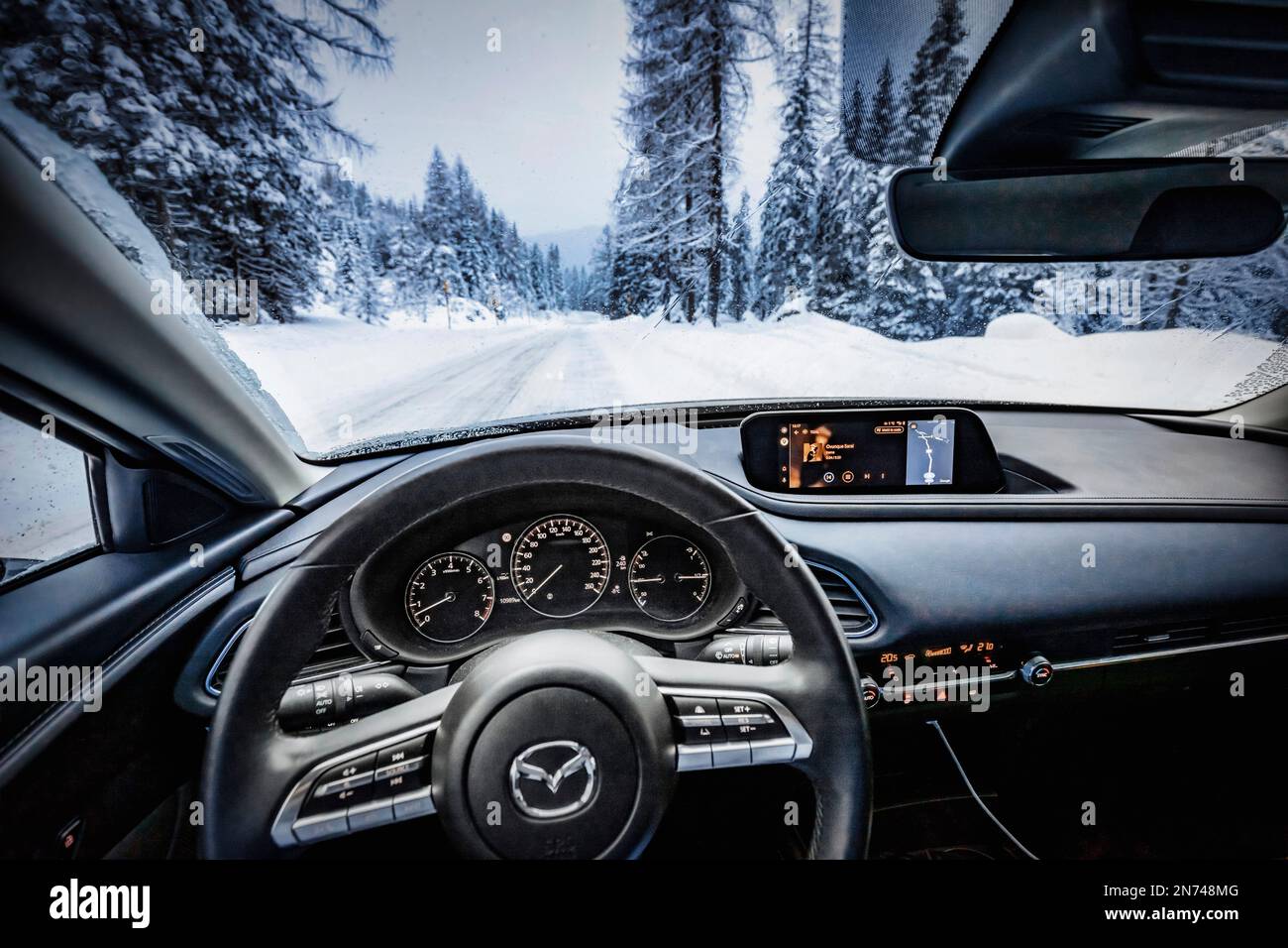 Italie, Vénétie, Belluno, une Mazda Motor Corp Véhicule utilitaire sport multisegment CX-30, vue intérieure, habitacle, conduite sur route enneigée en montagne Banque D'Images