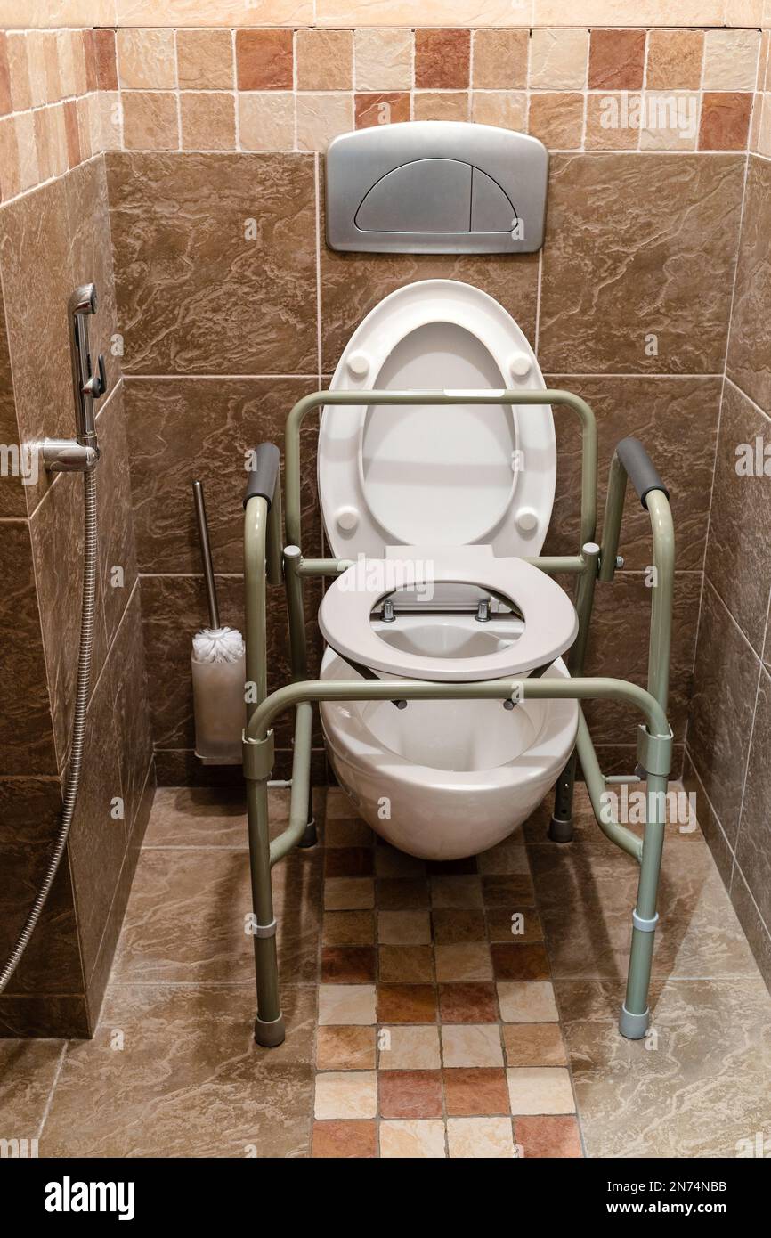 chaise sanitaire haute montée au-dessus des toilettes normales dans la salle de toilette de la maison Banque D'Images