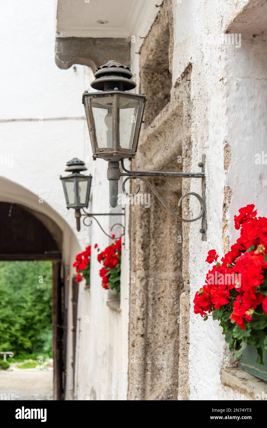 Lampe de rue et fleurs rouges à l'entrée du monastère Hoeglwoerth, Bavière, Allemagne Banque D'Images