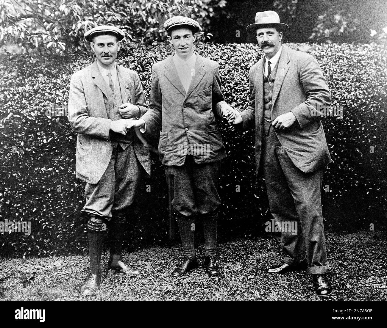 CORRECTS MIDDLE INITIAL TO D, NOT B - FILE - In this 1913 file photo, American golfer Francis D. Ouimet, center, shakes hands with Harry Vardon, left, and Ted Ray, both of Britain, at the U.S. Open golf championship at The Country Club in Brookline, Mass. Ouimet's U.S. Open victory at The Country Club 100 years ago helped turn him and caddie Eddie Lowery into household names and boosted the sports popularity in the United States. (AP Photo/File) Banque D'Images