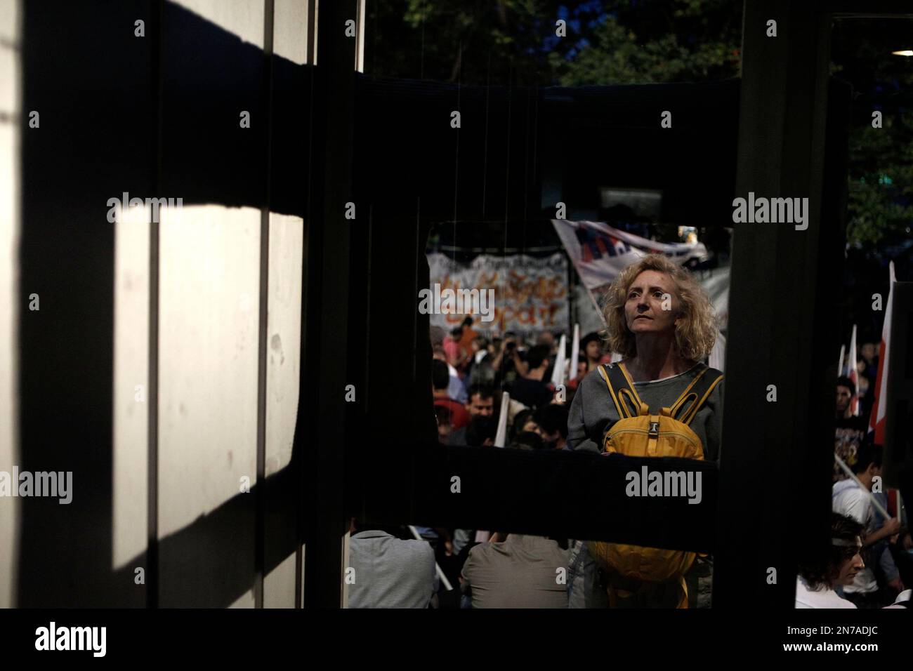 A protester looks at a mock TV screen at the entrance of the Greek state television ERT headquarters during a 24-hours General Strike in Athens, Thursday, June 13, 2013. Unions in Greece are holding a general strike following the closure of state-run TV and radio which has divided the government coalition.(AP Photo/Petros Giannakouris) Banque D'Images