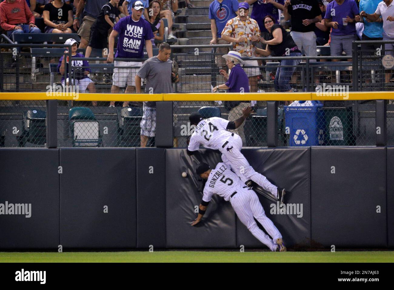 Colorado Rockies outfielder Dexter Fowler (24) collides with teammate Carlos Gonzalez as they chased a fly ball hit by Washington Nationals' Ryan Zimmerman for a double in the sixth inning of a baseball game on Wednesday, June 12, 2013, in Denver. (AP Photo/Joe Mahoney) Banque D'Images
