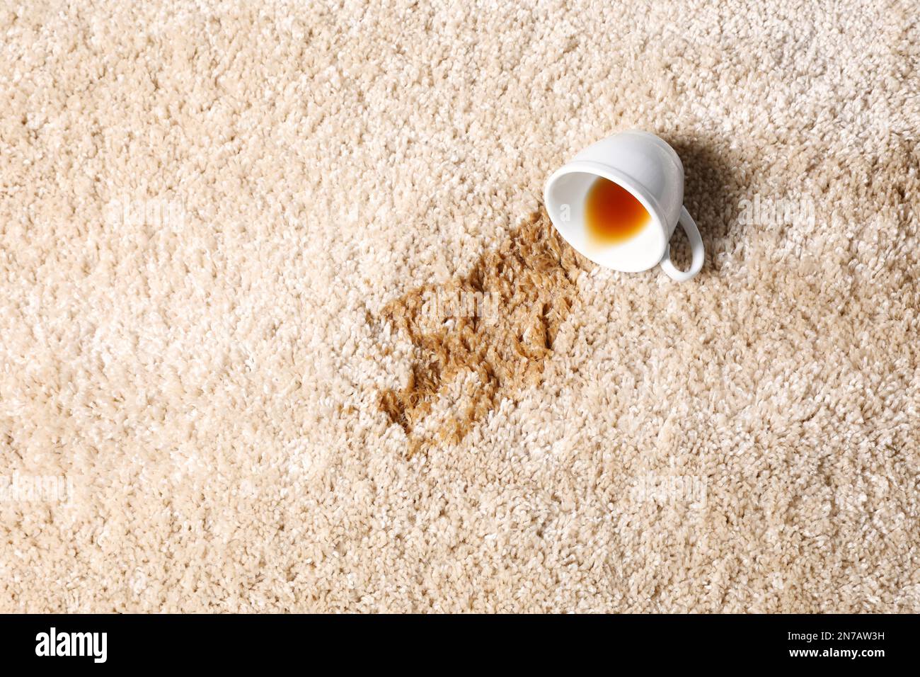 Tasse renversée et thé renversé sur la moquette beige, vue de dessus. Espace pour le texte Banque D'Images Tasse renversée et thé renversé sur la moquette beige, vue de dessus. Espace pour le texte Banque D'Images