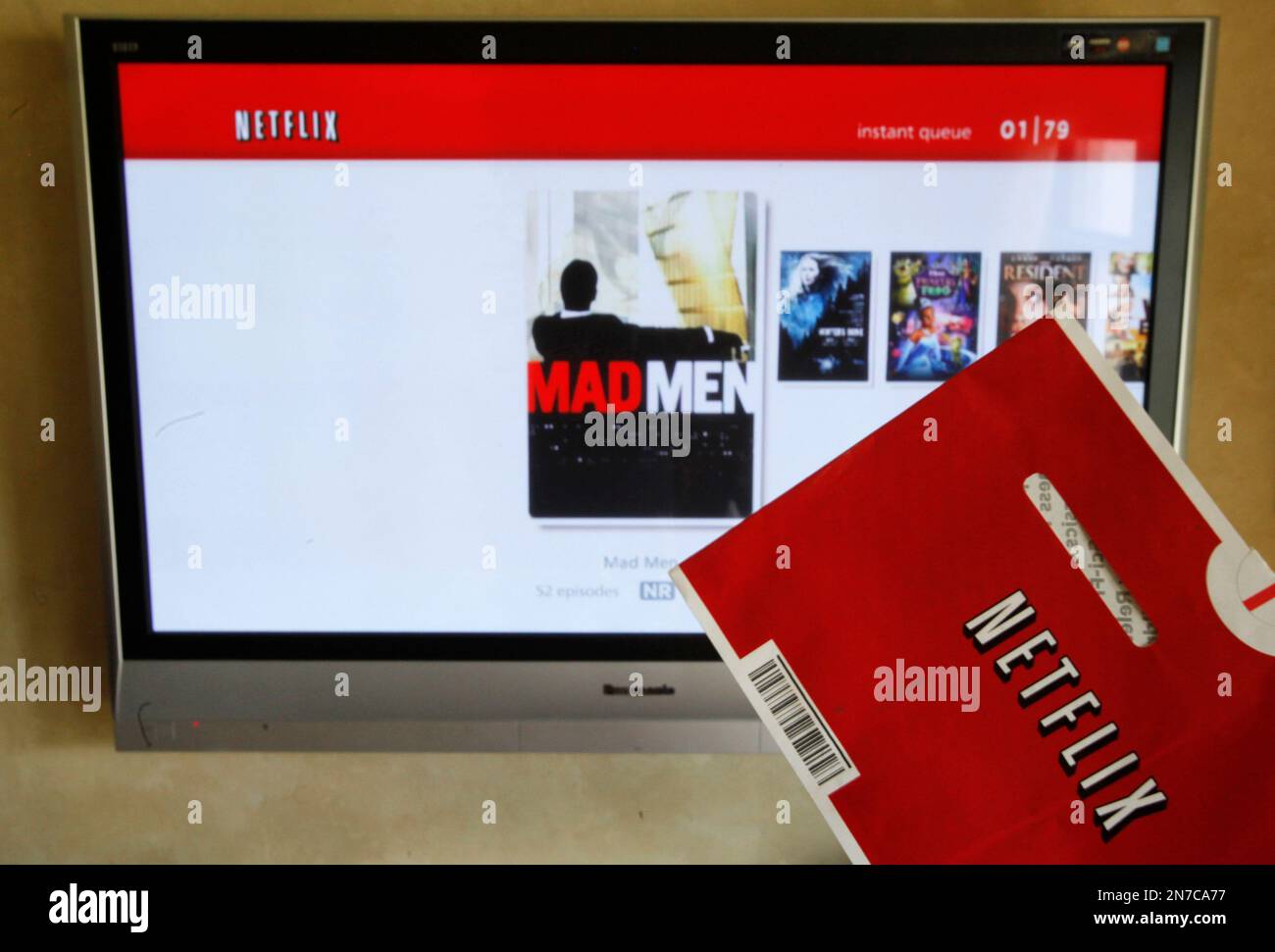 FILE - In this Oct. 1, 2011 file photo, a Netflix DVD envelope and Netflix on-screen television menu are shown in Surfside, Fla. Thinking about how you use your Netflix, Hulu or other video account, can lead to potentially cost-saving measures, depending on what features you desire and actually use the most. (AP Photo/Wilfredo Lee, File) Banque D'Images