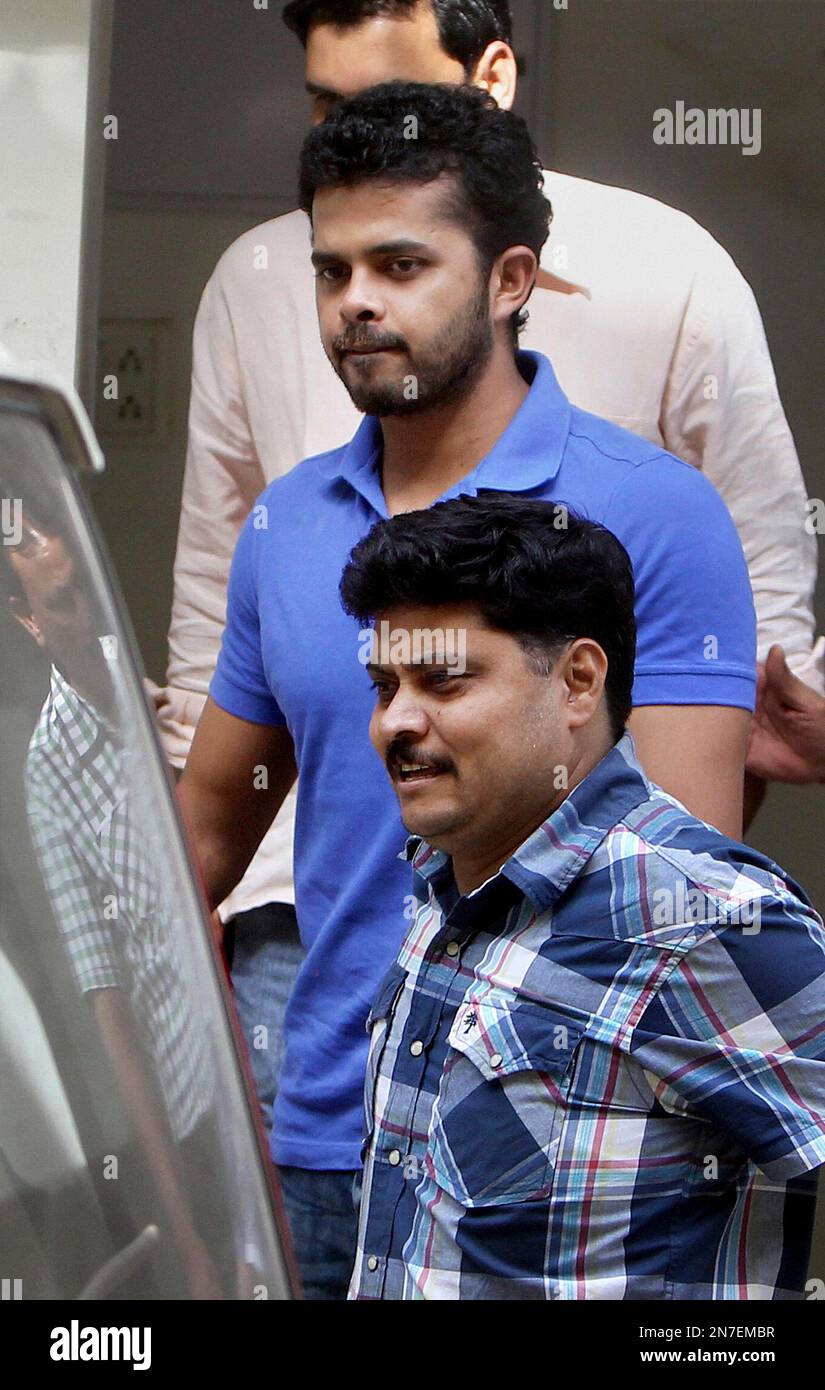 In this Tuesday, May 21, 2013 photo, India's Shantakumaran Sreesanth, in blue, walks towards a court in New Delhi, India. Sreesanth has claimed innocence in the spot-fixing scandal in a domestic Twenty20 cricket league, while he and two teammates from his Rajasthan-based team remain in police custody. (AP Photo) INDIA OUT Banque D'Images