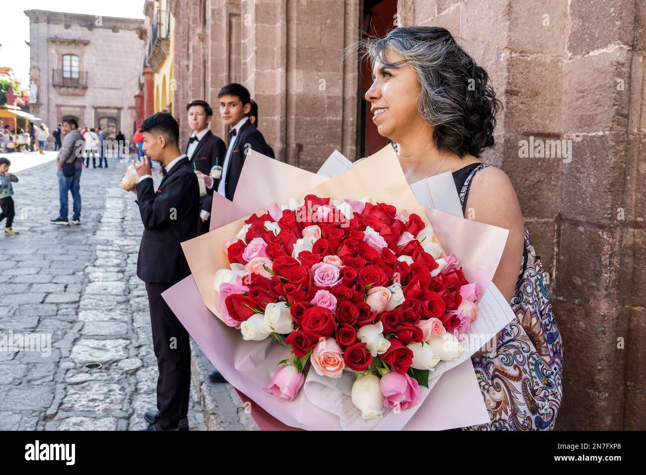 San Miguel de Allende Guanajuato Mexique, Historico Centre historique central Zona Centro, quinceanera arrivée de l'âge tradition partie, tenant des fleurs roses Banque D'Images