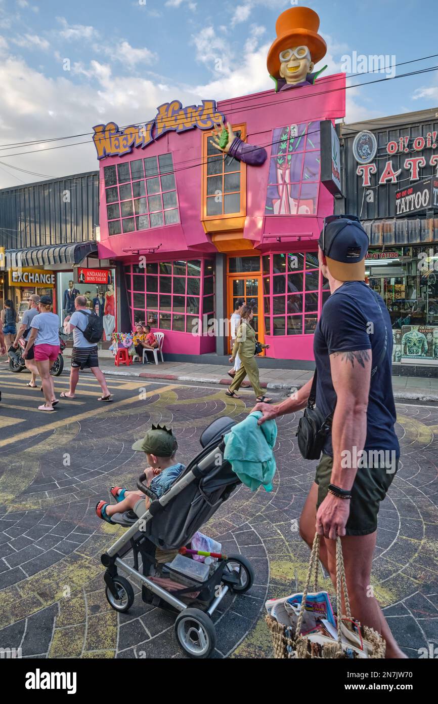 Un touriste occidental poussant un pram passant excentrique, magasin rose 'Wehly Wonka' vendant des produits de cannabis; Bangla Road, Patong, Phuket Banque D'Images