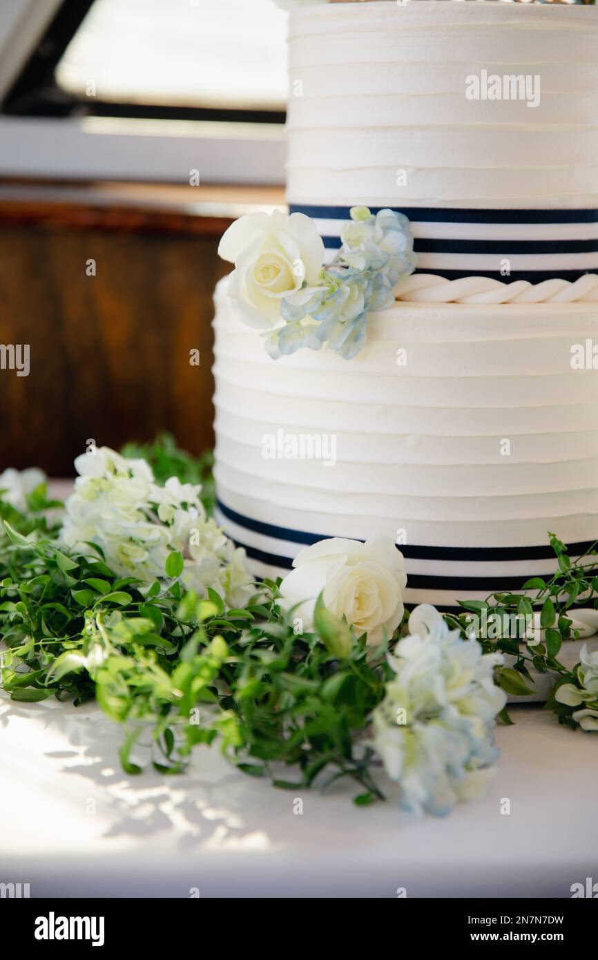 Gâteau de mariage blanc avec une décoration d'hortensia bleu et de roses, désert à deux niveaux sur le thème marin. Banque D'Images