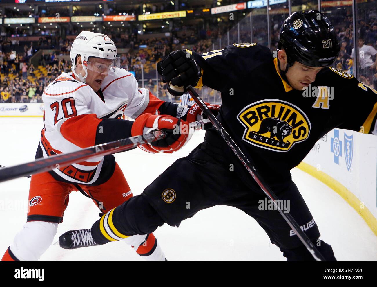 Carolina Hurricanes' Riley Nash (20) checks Boston Bruins' Andrew Ference (21) in the third period of an NHL hockey game in Boston, Monday, April, 8, 2013. The Bruins won 6-2. (AP Photo/Michael Dwyer) Banque D'Images