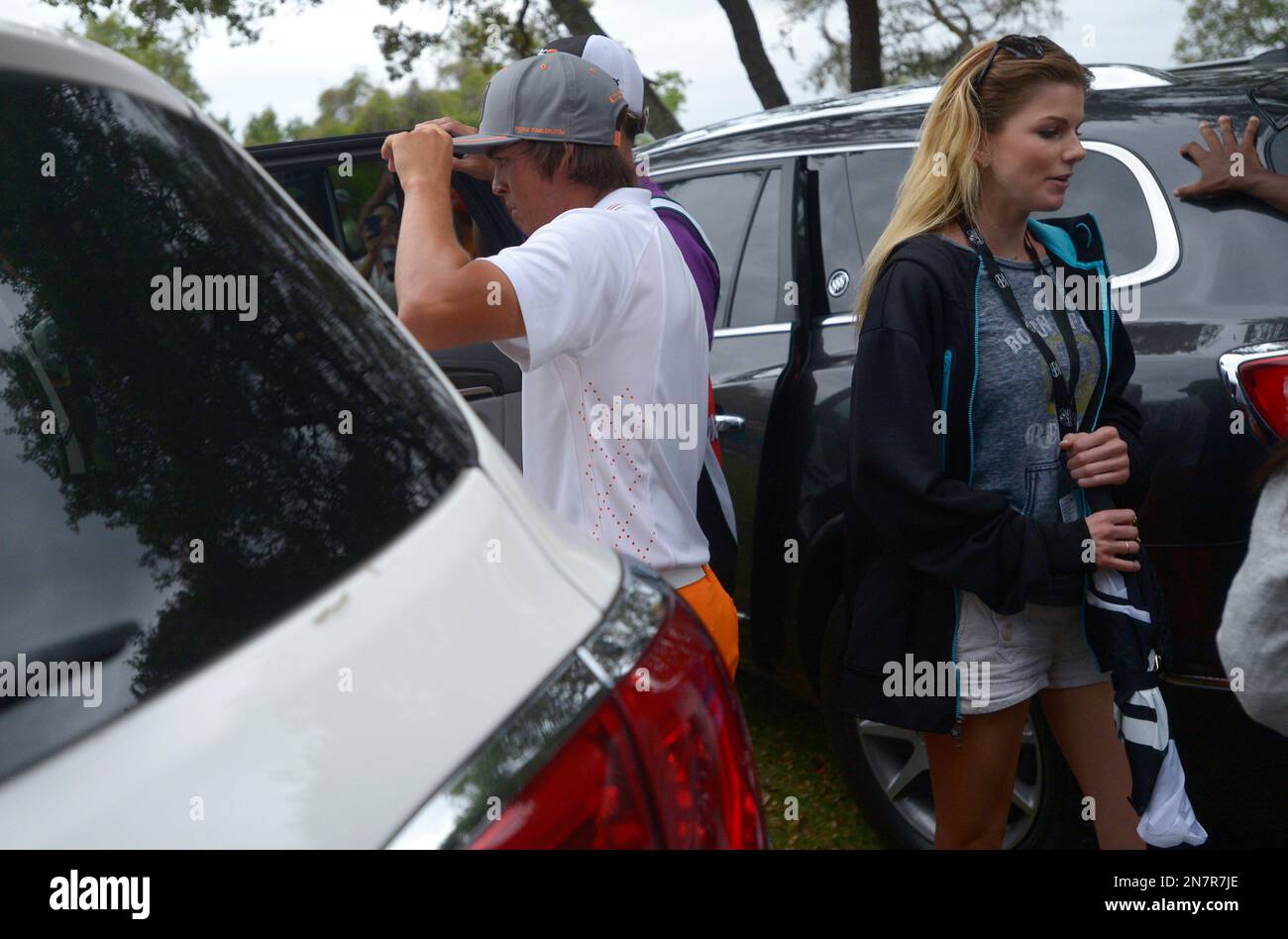 Rickie Fowler, left, and his girlfriend, Alexandra Browne, leave the course in awaiting vehicles behind the second green after players were called off the course due to an approaching severe thunderstorm during the final round of the Arnold Palmer Invitational golf tournament in Orlando, Fla., Sunday, March 24, 2013.(AP Photo/Phelan M. Ebenhack) Banque D'Images