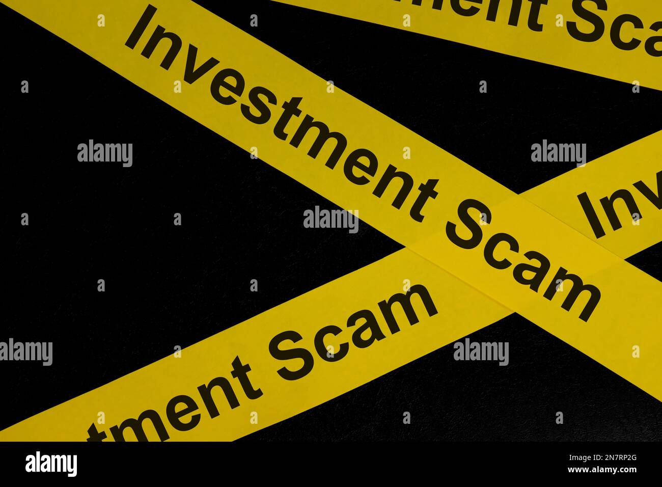 Escroquerie d'investissement et alerte à la fraude, mise en garde et avertissement. Ruban de barricade jaune avec mot sur fond noir foncé. Banque D'Images