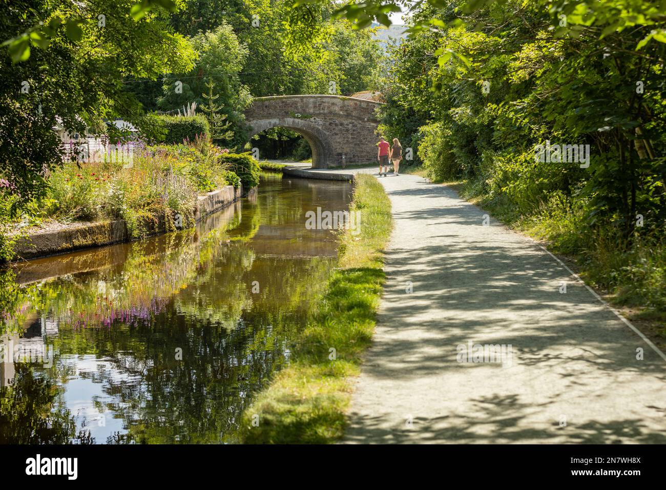 Llangollen pays de Galles royaume-uni 16 juillet 2022 Un homme et des femmes marchent le long d'un chemin de canal pendant un jour d'été colorfu, concept romantique, couple amoureux Banque D'Images