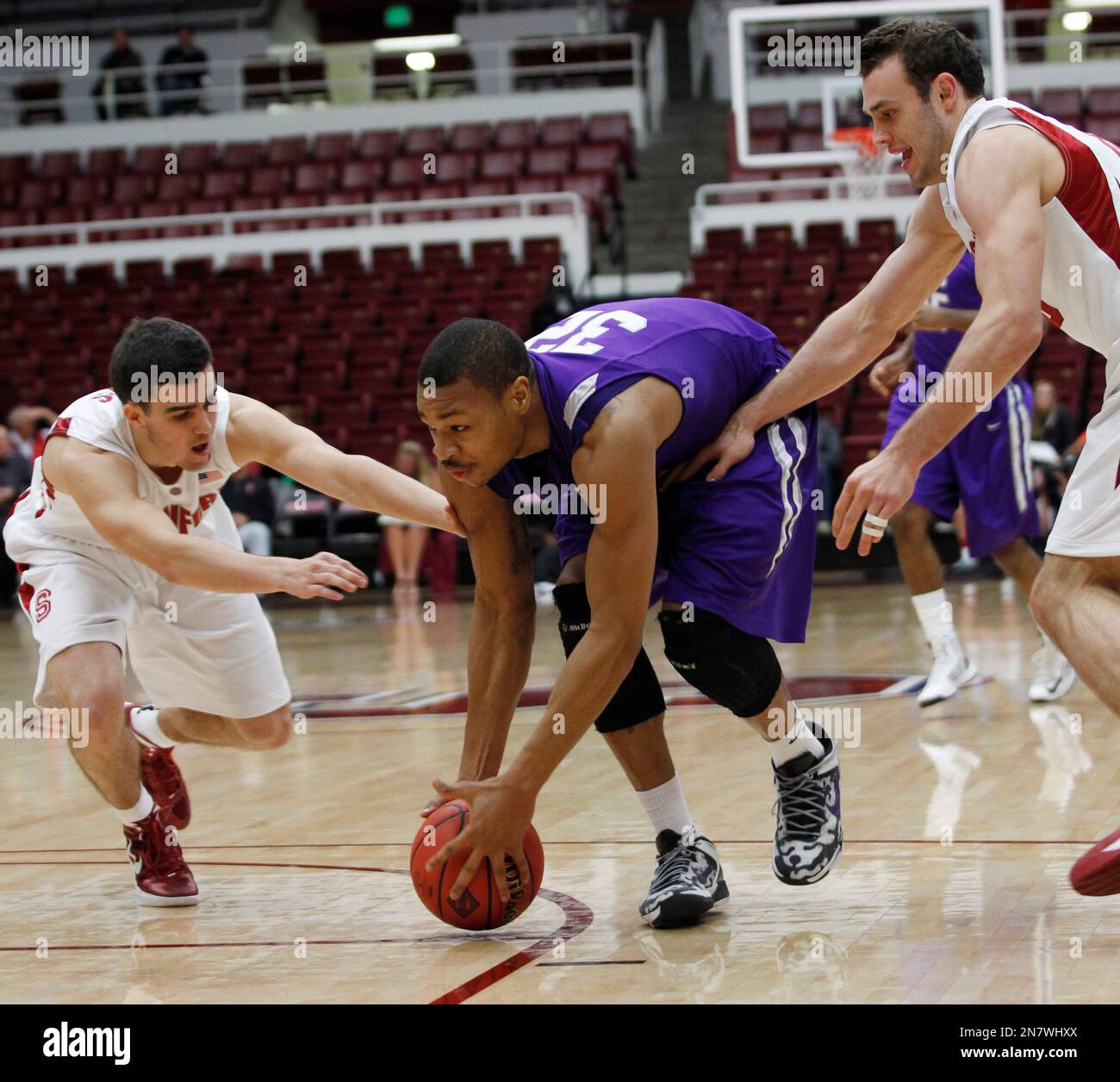 Stephen F. Austin's Taylor Smith, center, reaches for a loose ball between Stanford's Christian Sanders, left, and Robbie Lemons during the first half of a first-round NIT college basketball game, Tuesday, March 19, 2013, in Stanford, Calif. (AP Photo/George Nikitin) Banque D'Images