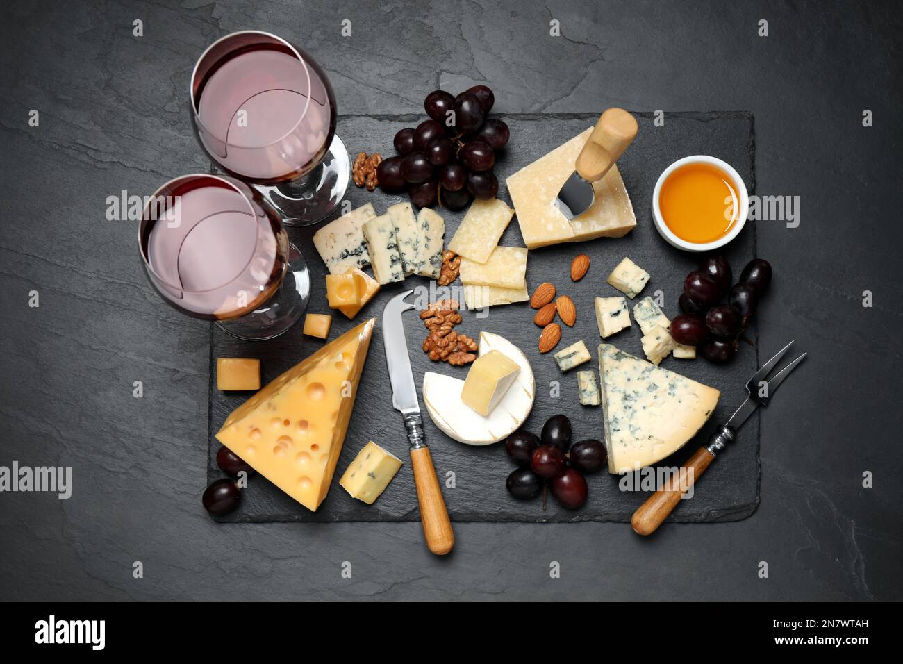 Plateau à fromage avec couteau spécialisé et fourchette sur table noire, plat Banque D'Images