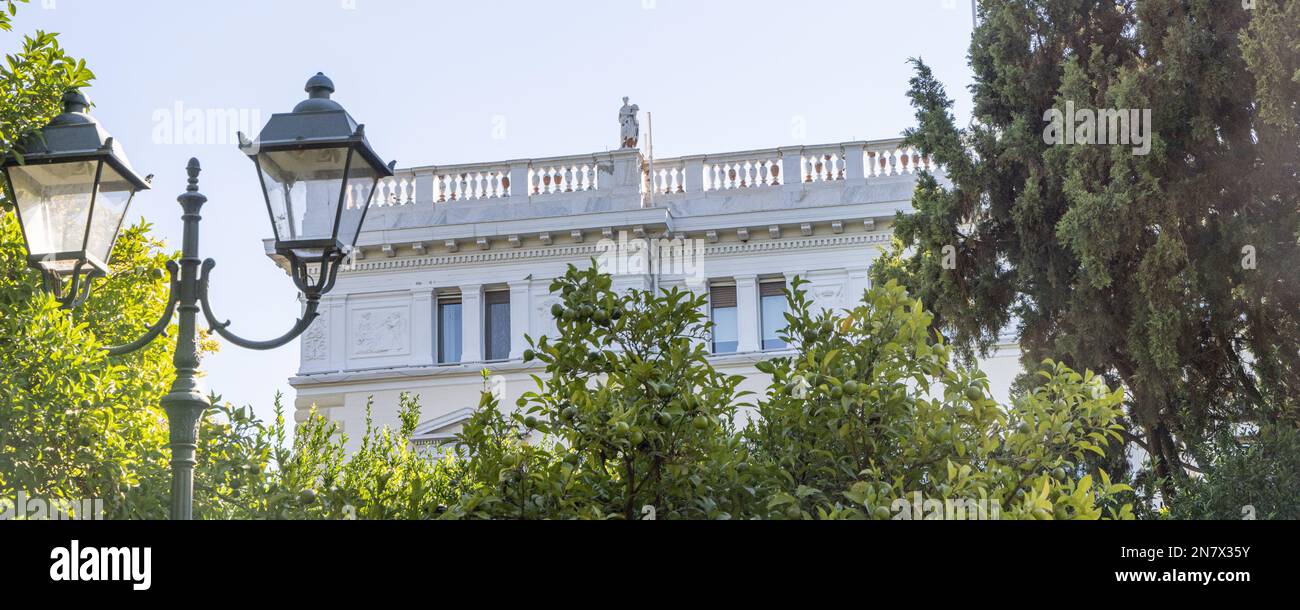 Bannière avec des arbres qui cachent le palais royal de la preuve dans le centre d'Athènes en Grèce Banque D'Images