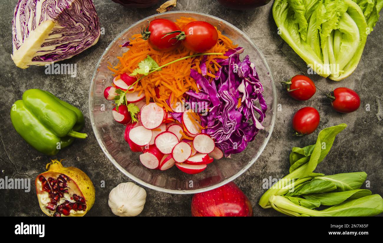 vue panoramique bol en verre à salade frais entouré de légumes et de fruits Banque D'Images