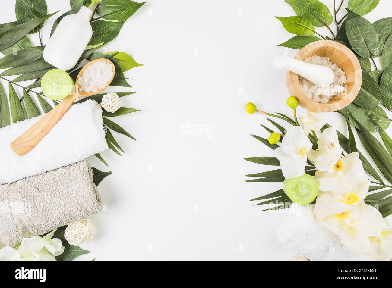 serviettes de vue à angle élevé sel bougies fleurs feuilles de surface blanche Banque D'Images