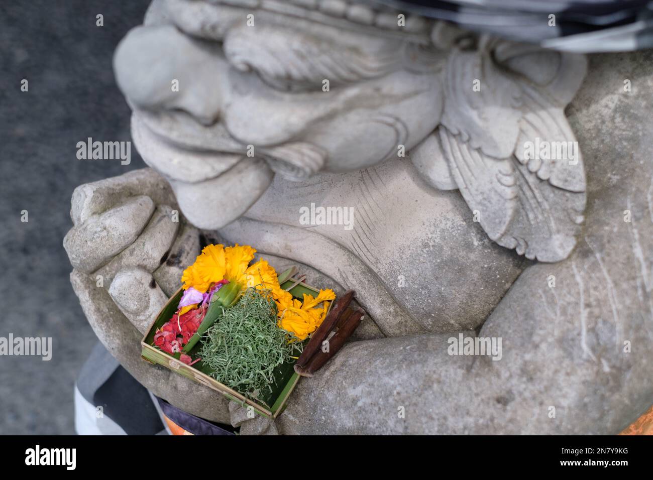 La statue de garde-porte est faite de pierre recouverte de tissu sacré