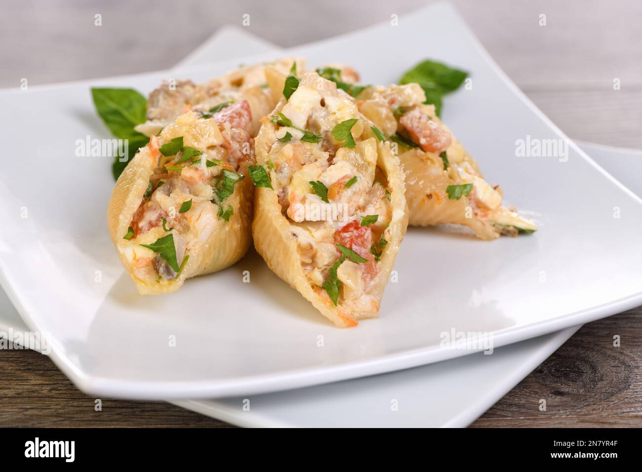 Pâtes Conchiglioni farcies de morceaux de poulet tendres, de champignons et de légumes dans une riche sauce crémeuse. Banque D'Images