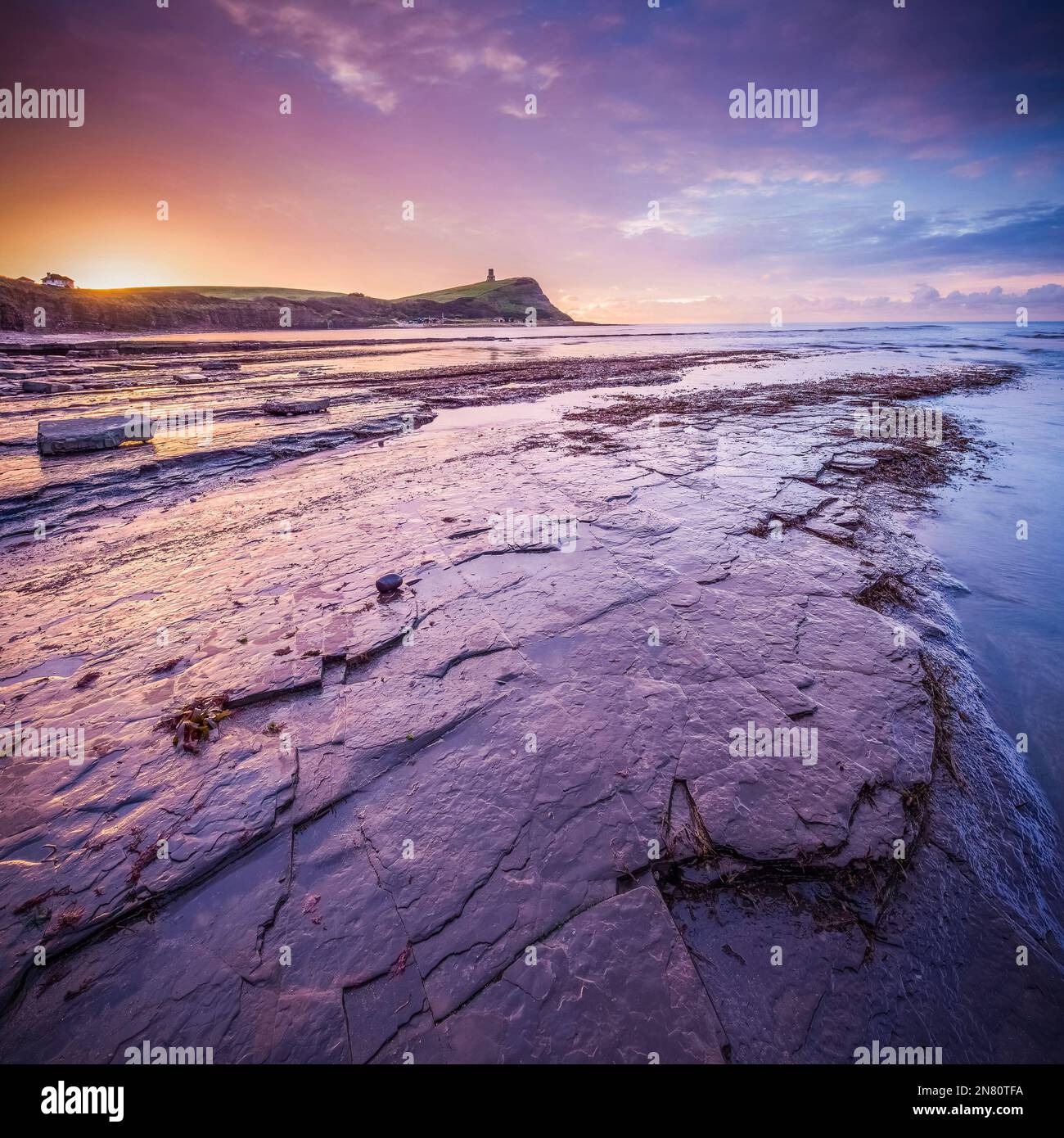 Kimmeridge, Royaume-Uni - magnifique lever de soleil coloré avec phare, rochers et marée basse à Kimmeridge Bay, Dorset, Royaume-Uni Banque D'Images