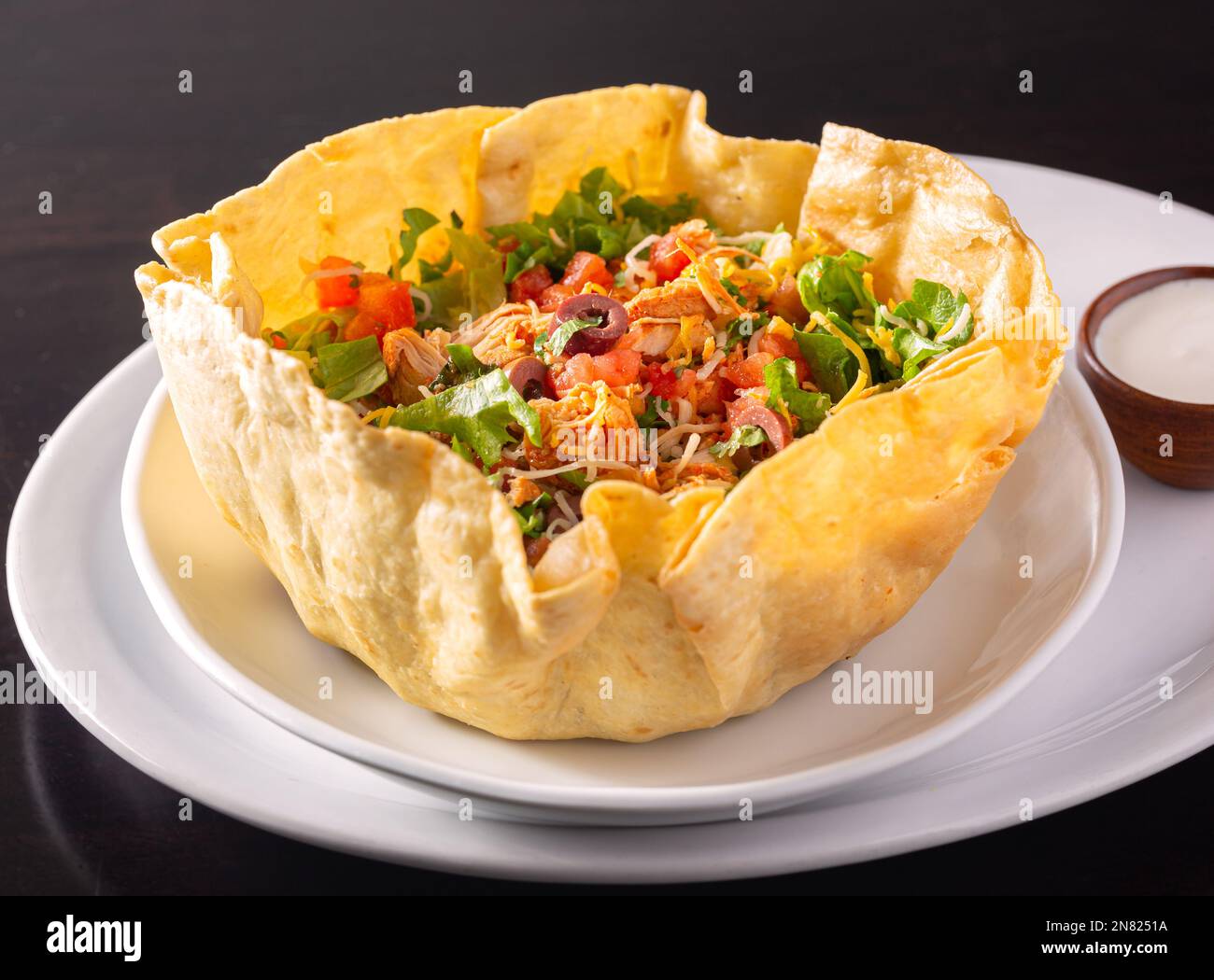 Sald de tacos frais dans un bol blanc avec de la crème aigre sur le côté Banque D'Images