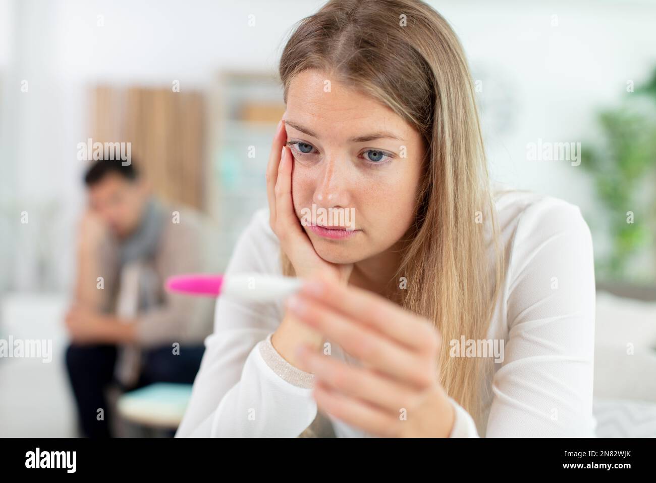 femme contrariée regardant un test de grossesse avec son mari Banque D'Images