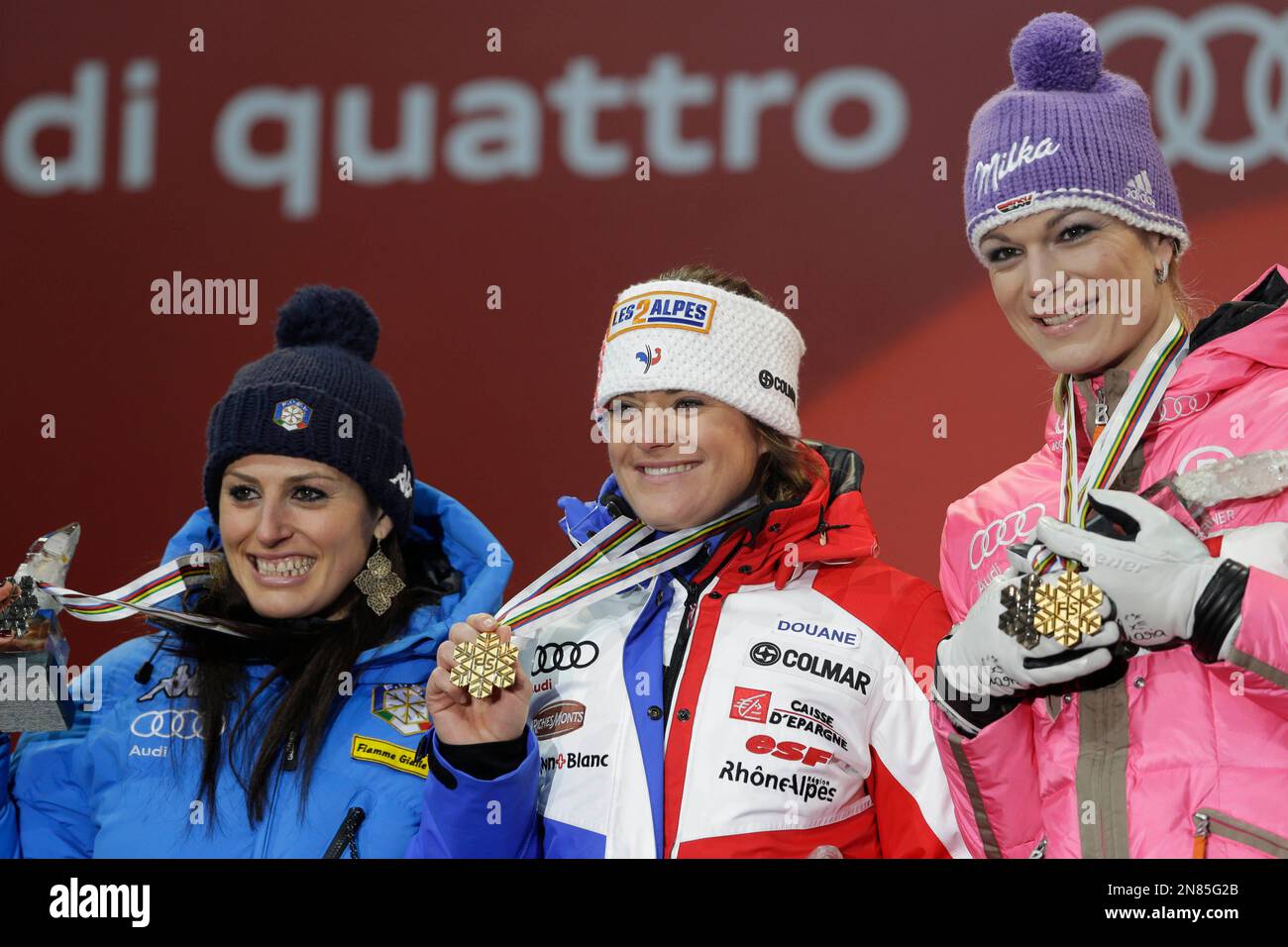 Gold medal's winner Marion Rolland, of France, center, is flanked by silver medalist Nadia Fanchini, of Italy, left, and bronze medalist Germany's Maria Hoefl-Riesch during the medal ceremony for the women's downhill, at the Alpine skiing world championships in Schladming, Austria, Sunday, Feb.10, 2013. (AP Photo/Luca Bruno) Banque D'Images