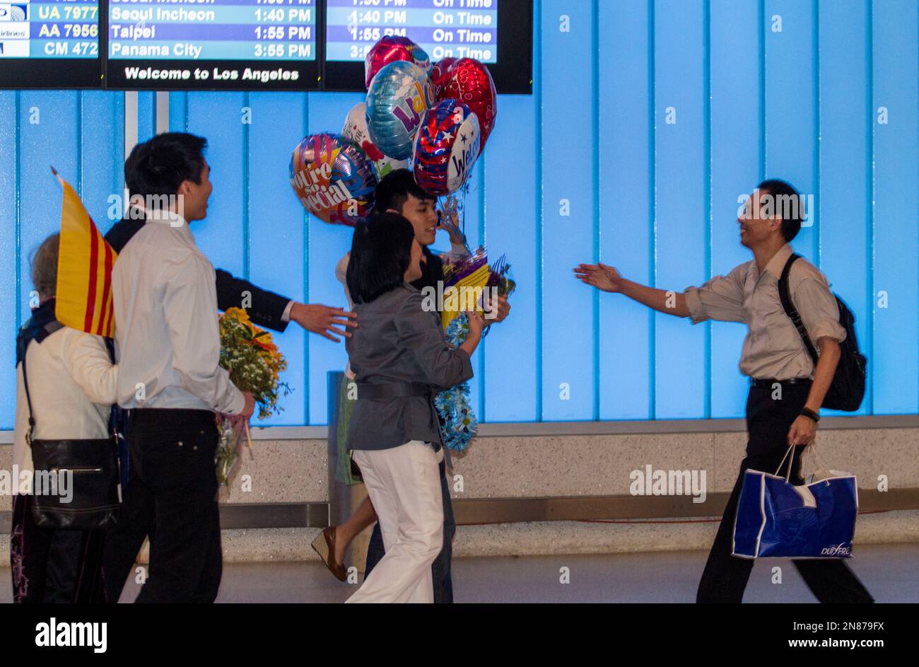 The family of Nguyen Quoc Quan welcome his arrival at the Los Angeles International Airport from Vietnam on Wednesday, Jan. 30, 2013, in Los Angeles. Quan, a human rights activist, has been released after being detained since April 17, 2012 in Ho Chi Minh City, Vietnam. (AP Photo/Ringo H.W. Chiu) Banque D'Images