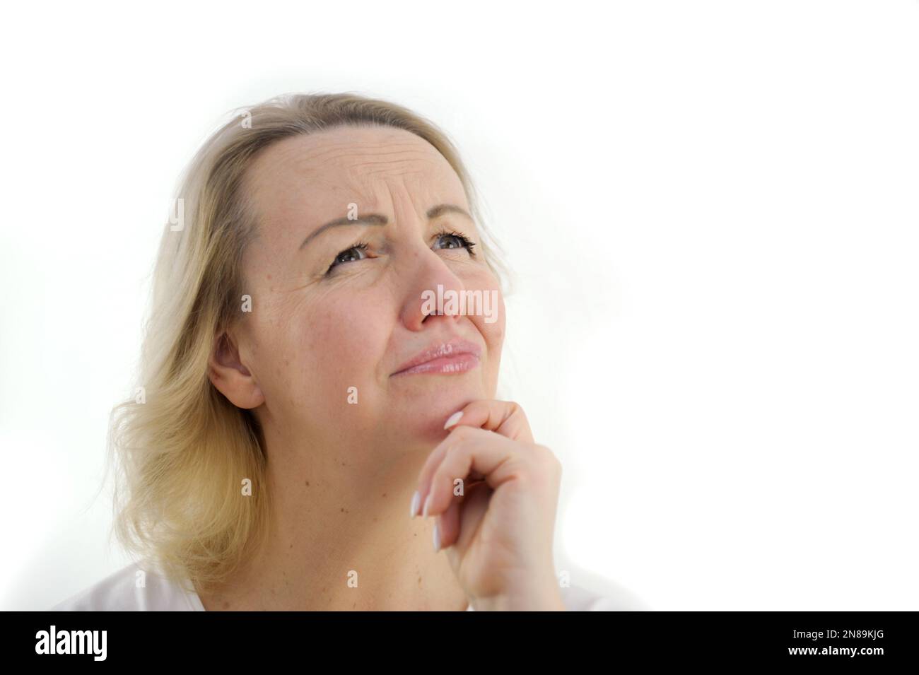 fond blanc triste femme conçue a soulevé le visage les yeux en haut les yeux abaissés, va pleurer, larmes, lèvres tordues, triste grimace main près du menton la nuisance de l'attente, la frustration, la tristesse, les rêves insatisfaits Banque D'Images