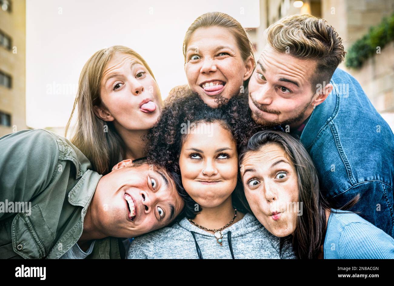 Des gens multiculturels et miléniaux qui prennent le selfie en tenant la langue avec des visages drôles - style de vie fou et concept d'intégration avec des amis interraciaux Banque D'Images